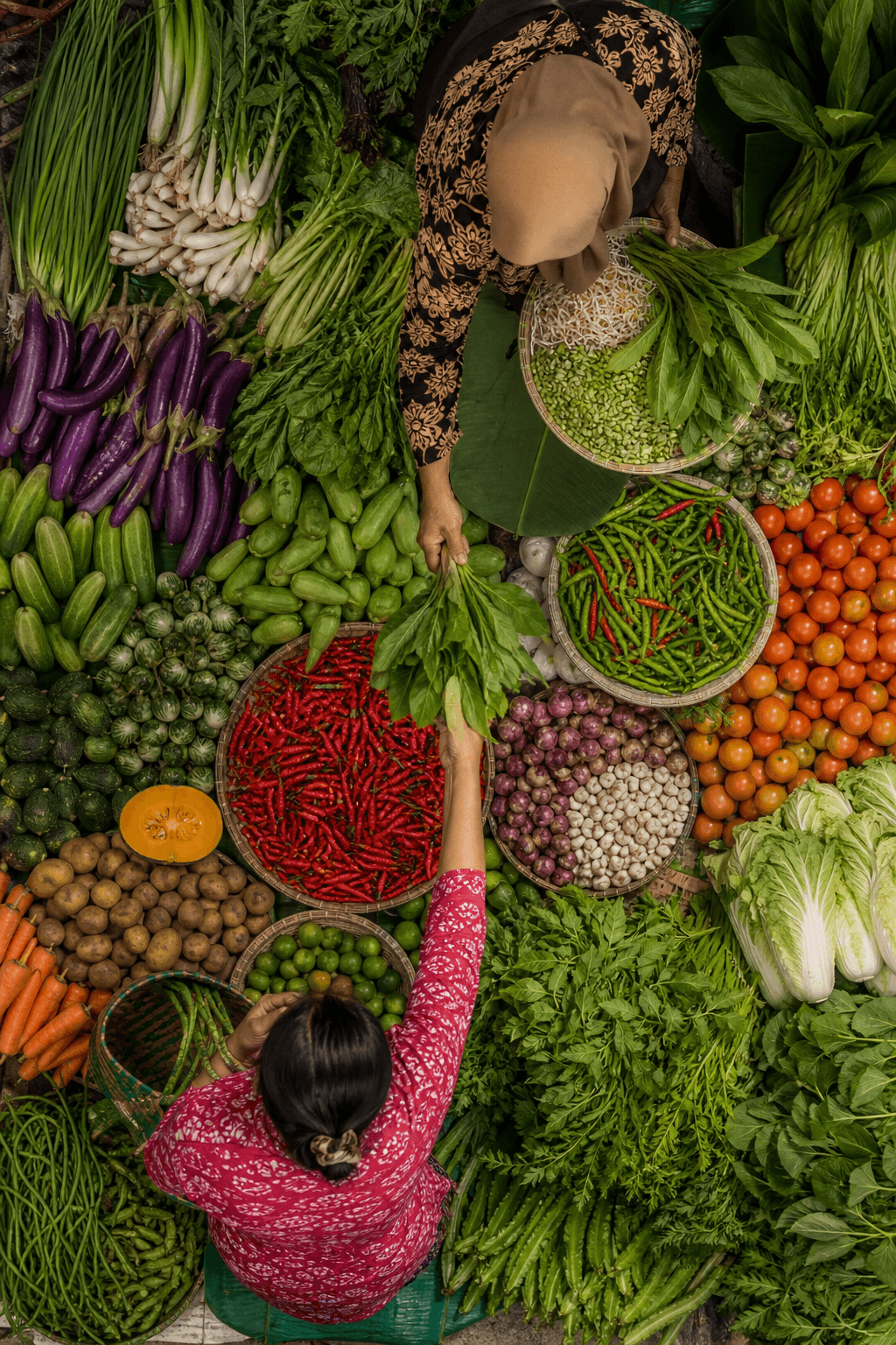 An Indonesian market filled with fresh vegetables and shoppers