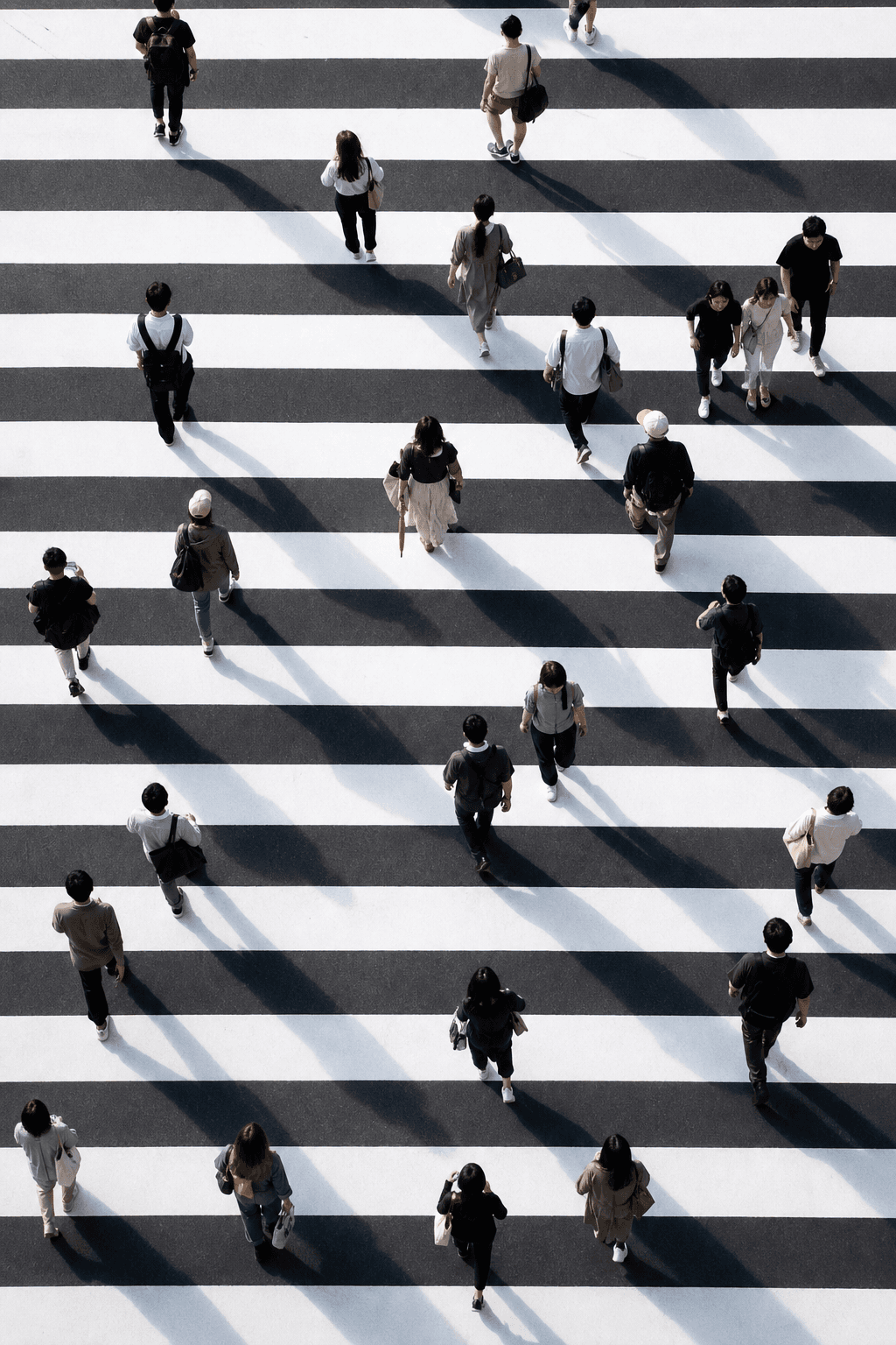 People walking across a graphic black-and-white crossing